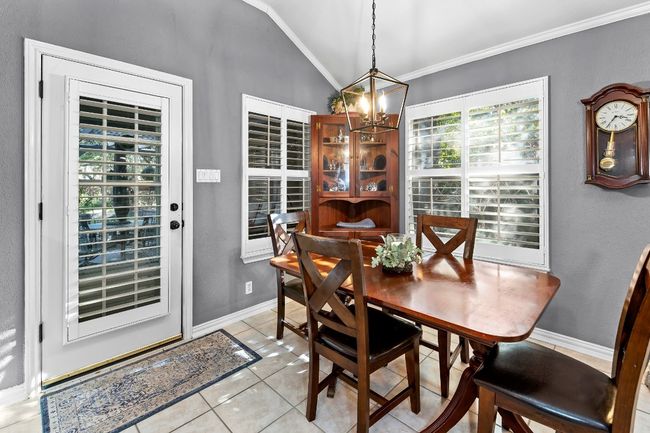 Tiled dining room with crown molding, lofted ceiling, and a notable chandelier | Image 17