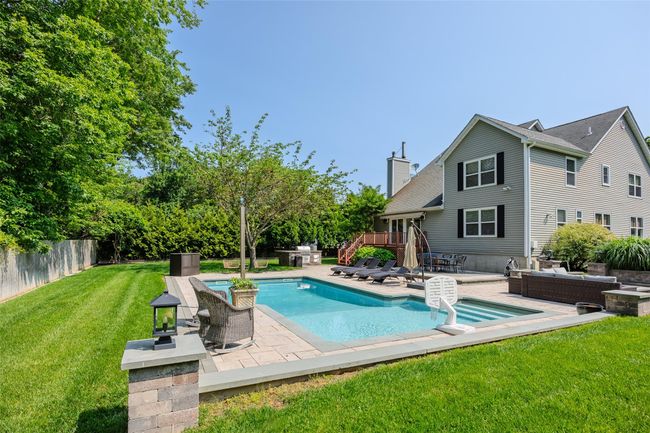 View of pool with a fenced backyard, a patio area, and a wooden deck | Image 37