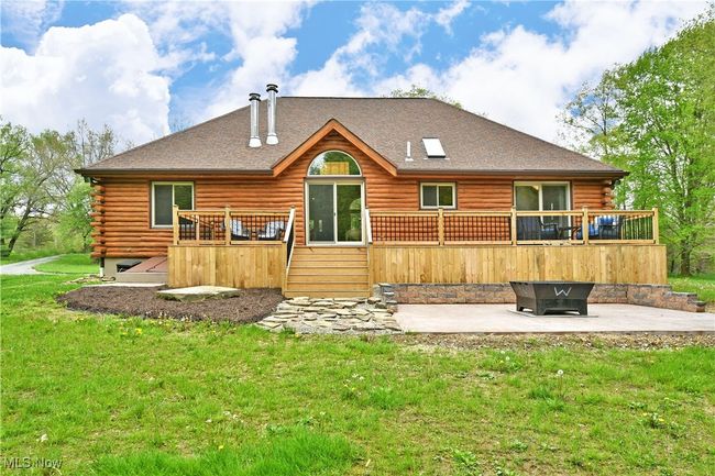 Back of property with a patio area, log exterior, a wooden deck, and a lawn | Image 47