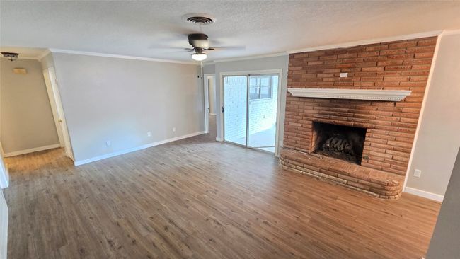 Family room with wood fireplace and crown moulding. | Image 9