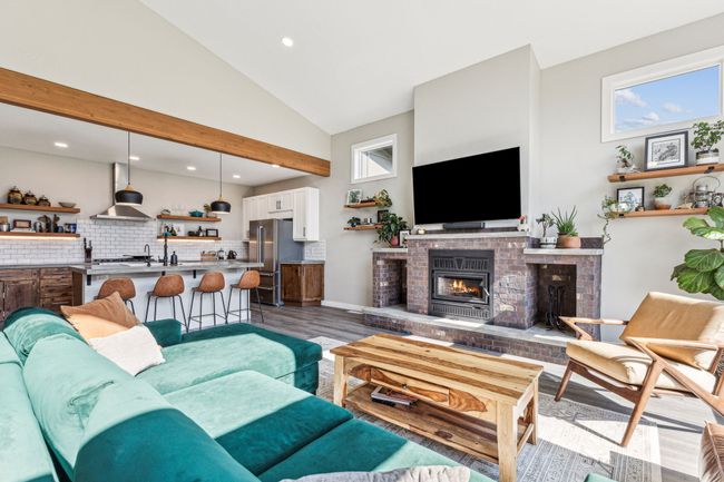 Living room with a brick fireplace, wood finished floors, recessed lighting, and high vaulted ceiling | Image 17
