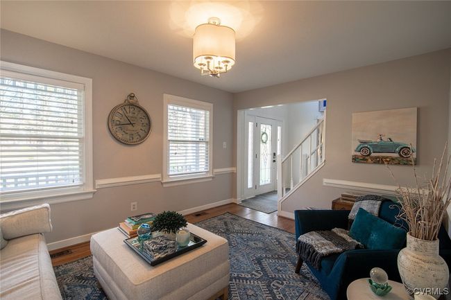 Living room featuring wood finished floors, visible vents, baseboards, stairs, and a notable chandelier | Image 6