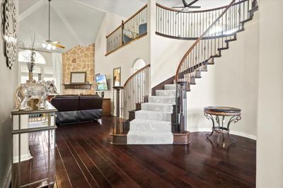 Stairs featuring ceiling fan, hardwood / wood-style flooring, and high vaulted ceiling | Image 3