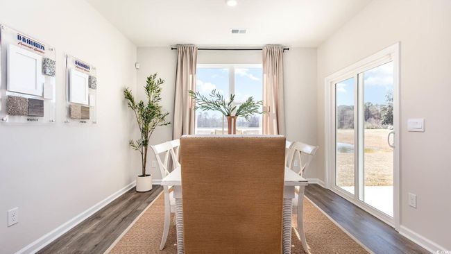 Dining area featuring dark wood-type flooring, baseboards, visible vents, and a wealth of natural light | Image 7