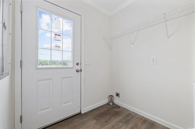 Laundry area with electric dryer hookup, crown molding, and dark wood-style flooring | Image 18