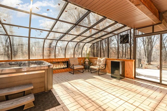 The sunroom is a perfect place to entertain. It opens through the sliding glass doors onto a concrete patio. There is also access through the 1-car garage. The room has a 50 amp heater, an exhaust fan, & easy to maintain tiled floors. | Image 11