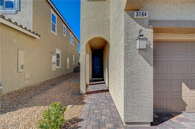 View of exterior entry featuring stucco siding, a garage, and central air condition unit | Image 4
