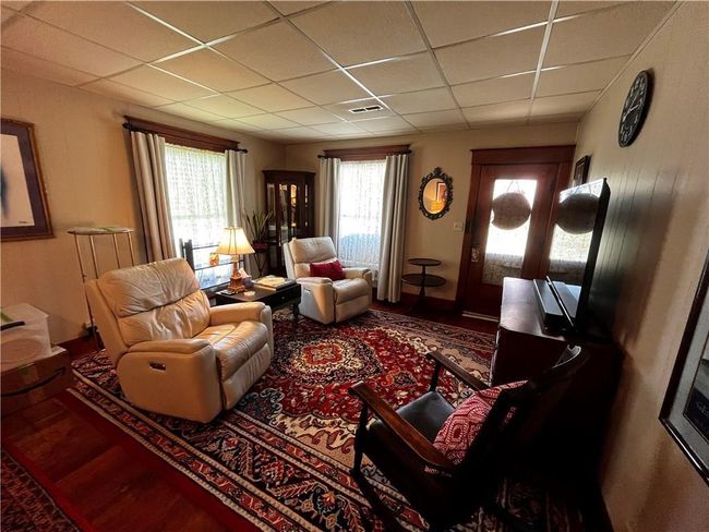 Living room with a paneled ceiling and wood finished floors | Image 11