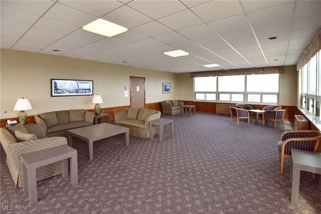 Carpeted living area featuring a wainscoted wall, wooden walls, and a healthy amount of sunlight | Image 32