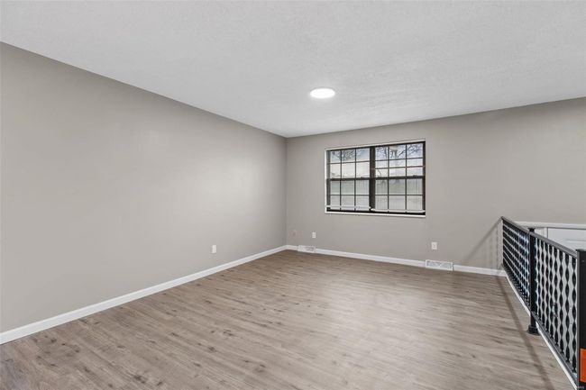 Empty room with baseboards, visible vents, and light wood-type flooring | Image 4