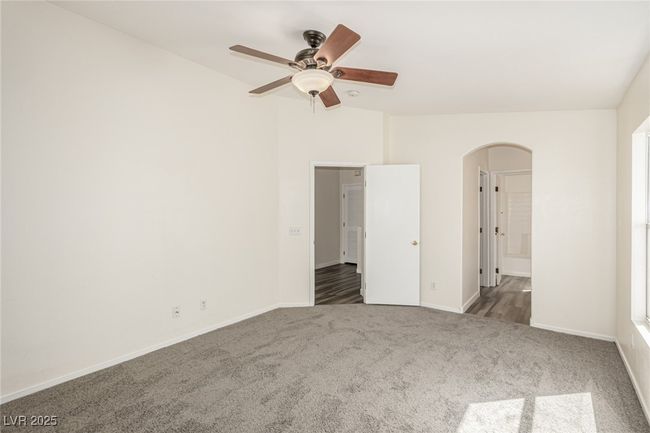 Carpeted primary featuring arched walkways, ceiling fan, and baseboards | Image 11