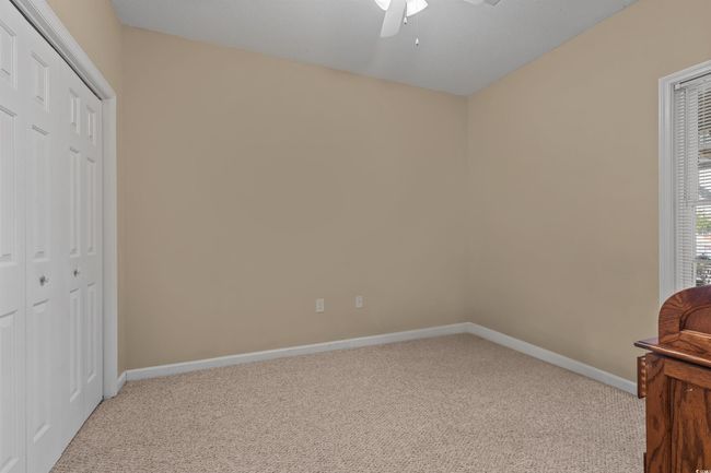 Unfurnished bedroom featuring carpet flooring, baseboards, a closet, and a ceiling fan | Image 9