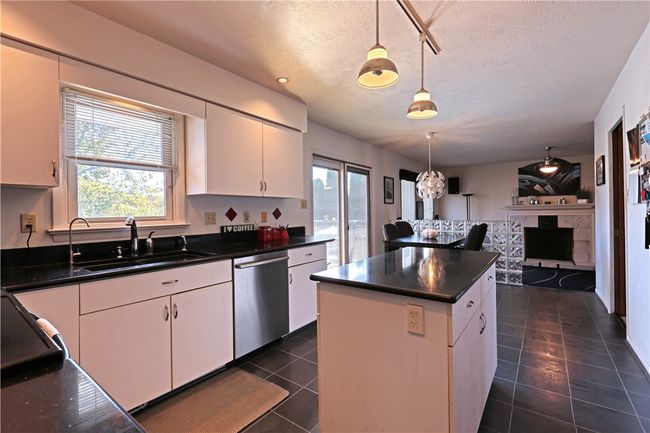 The black quartz countertops are a more recent addition to the kitchen, as well as the flooring and stainless steel refrigerator. | Image 6