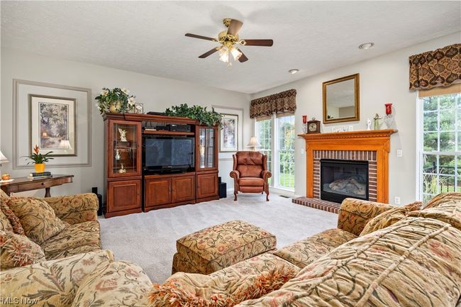 Living room with a wealth of natural light, light carpet, and a brick fireplace | Image 17