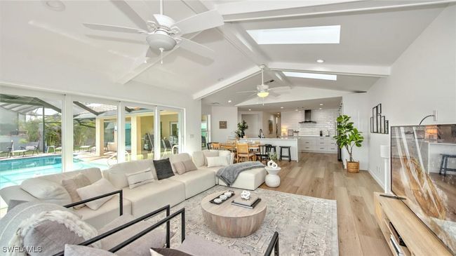 Living area with ceiling fan, light wood-style flooring, a skylight, and recessed lighting | Image 12