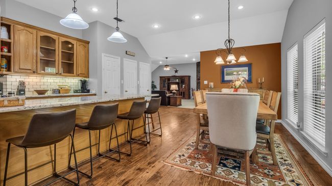 Dining area with high vaulted ceiling, dark wood-style flooring, an inviting chandelier, and recessed lighting | Image 8