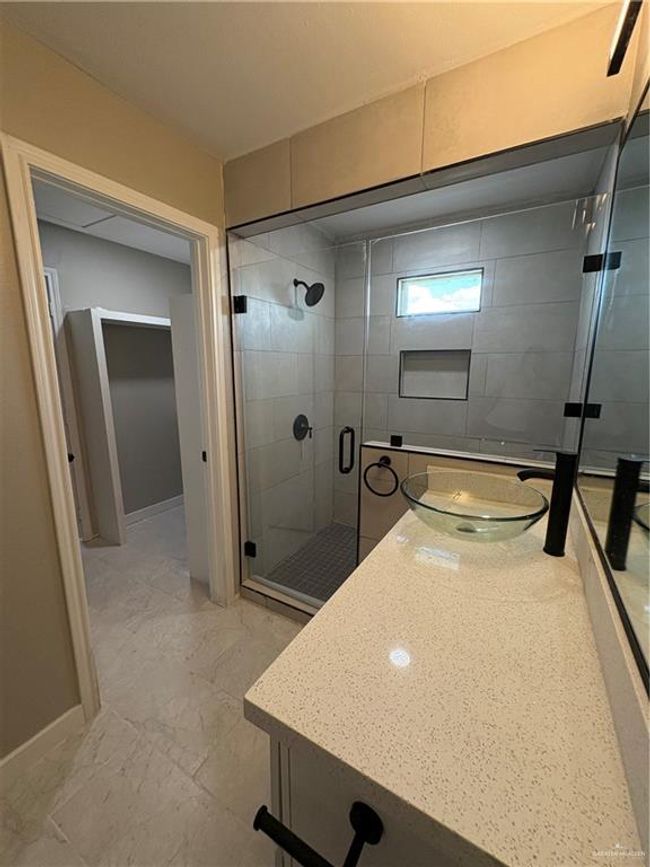 Full bathroom featuring vanity, a shower stall, and marble look tile flooring | Image 8