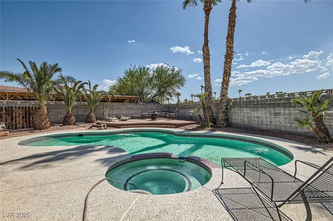 View of swimming pool with a patio, a fenced backyard, and a pool with connected hot tub | Image 28