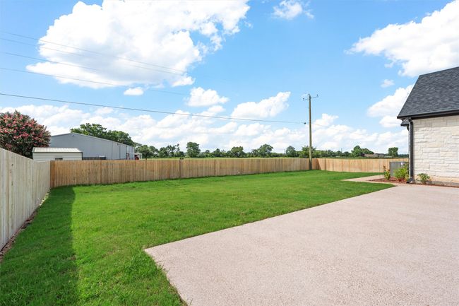 Fenced backyard with a patio | Image 32