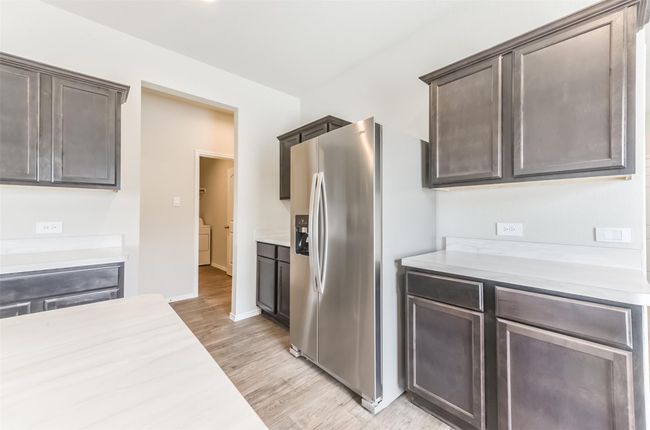 Off the kitchen, you will find the laundry room. | Image 16