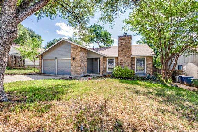 Single story home with driveway, fence, brick siding, a front lawn, and a garage | Image 7