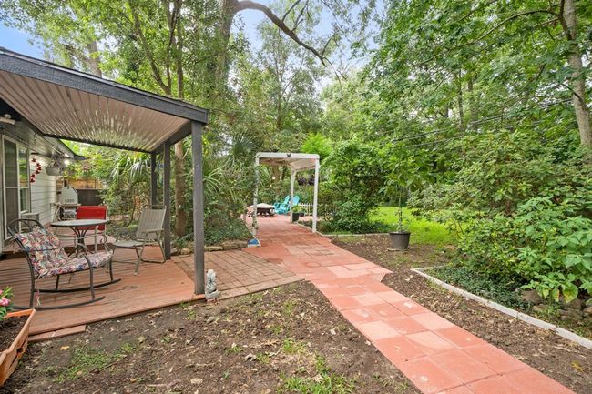 Enjoy the shade from the quaint covered patio looking out into your own private fenced forest. | Image 31