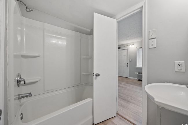 Full bath featuring wood finished floors, tub / shower combination, vanity, and baseboards | Image 12