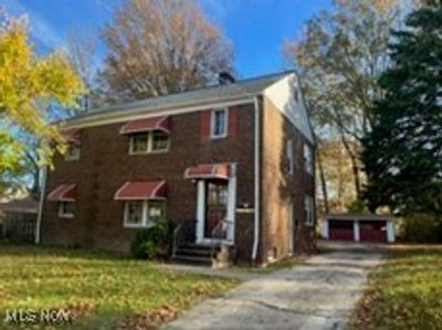 View of front facade with an outbuilding, a front yard, and a garage | Image 2