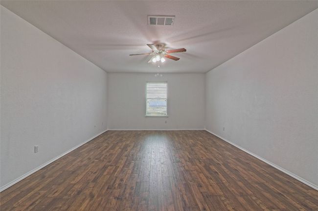 Unfurnished room featuring ceiling fan and dark wood-style flooring | Image 23