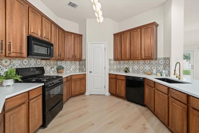 Kitchen with 42" upper cabinets, breakfast bar, deep sink, modern faucet, open to living. | Image 14