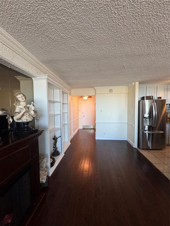 Corridor featuring hardwood / wood-style flooring, a textured ceiling, and crown molding | Image 5