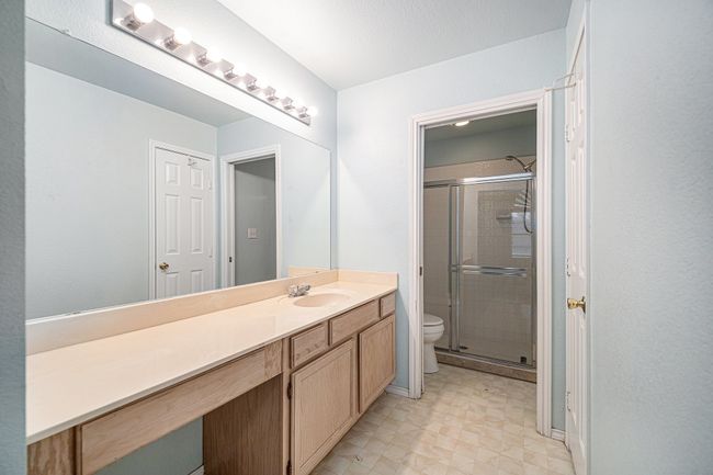 Lot of vanity space, drawers and cabinets. Linen closet on the right. There is a pocket door to separate walk-in shower and toilet are. | Image 12