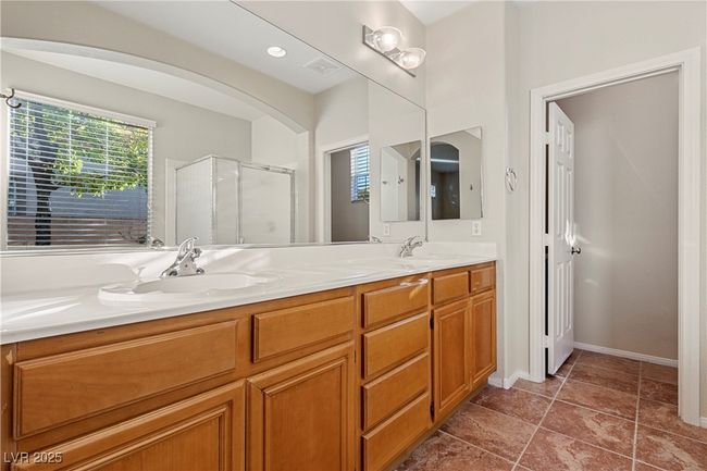 Bathroom featuring a shower stall, double vanity, and plenty of natural light | Image 25