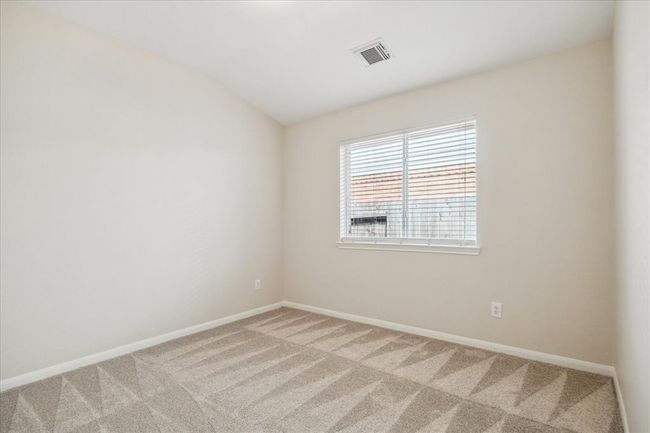 Here is a different angle of the third bedroom noting a cathedral-like ceiling adding to an airy and open feeling of space. You can arrange bedroom furniture in various configurations in this bedroom, all on fresh new carpet. | Image 22