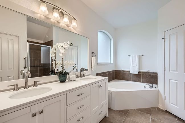 Full bathroom with double vanity, a stall shower, a bath, and tile patterned flooring | Image 12