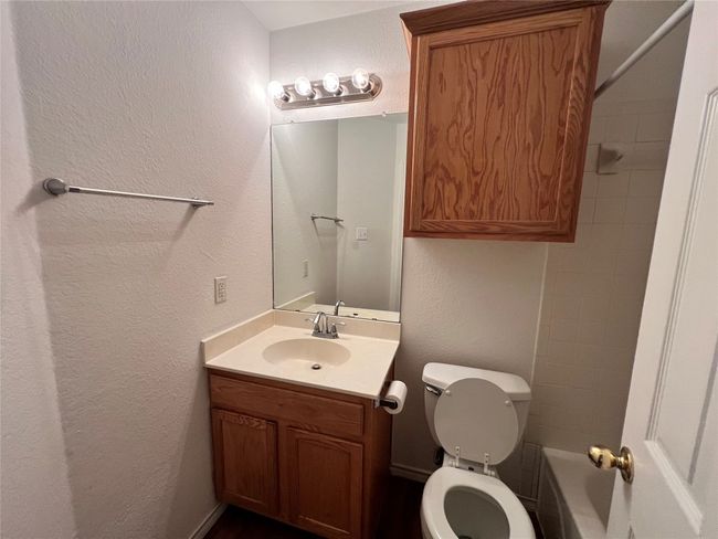 Full bathroom with toilet, vanity, and a textured wall | Image 12