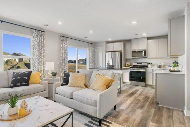 The rest of the main level pours out from the kitchen space, which flows straight into an open-concept styled living and dining area! (Photo of model, colors may vary) | Image 5