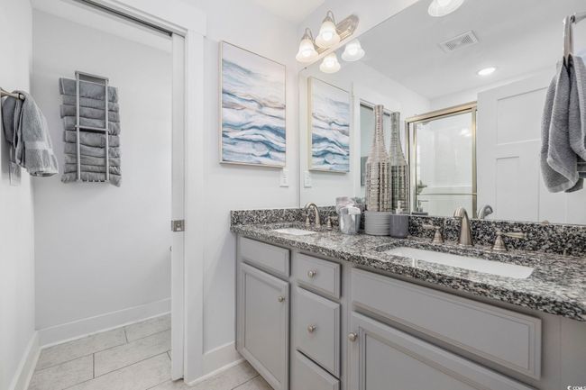 Bathroom with a shower stall, baseboards, a sink, and visible vents | Image 31