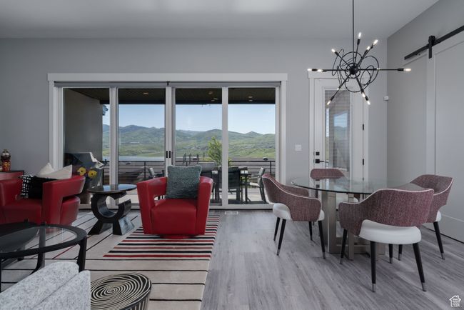 Living room with wood finished floors, a barn door, a mountain view, and healthy amount of natural light | Image 7