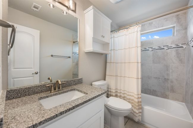 Full bathroom featuring vanity, shower / bath combination with curtain, and tile patterned flooring | Image 28