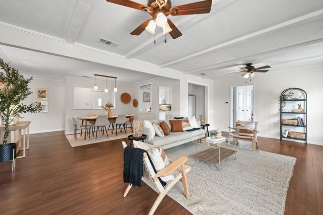 Living area with ceiling fan, dark wood-type flooring, baseboards, and beamed ceiling | Image 4