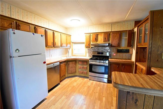 Kitchen with stainless steel appliances, light hardwood / wood-style floors, and decorative backsplash | Image 22