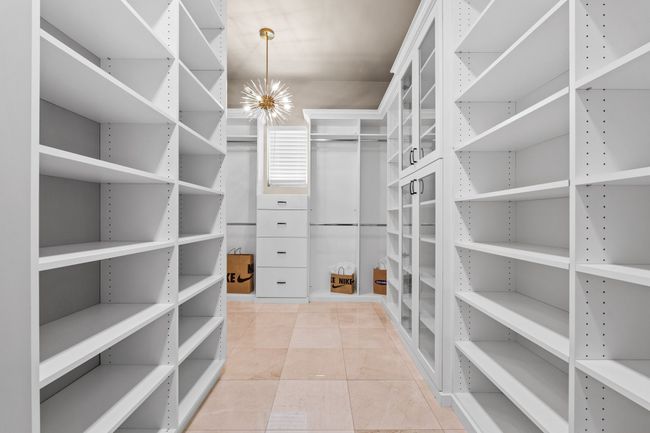 Spacious closet featuring a chandelier and tile patterned floors | Image 21