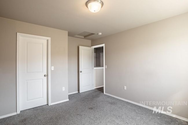 Unfurnished bedroom featuring baseboards and dark colored carpet | Image 16