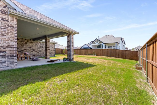 Fenced backyard with a patio | Image 39