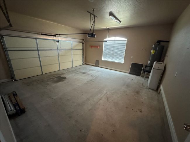 Garage with a garage door opener and water heater | Image 19