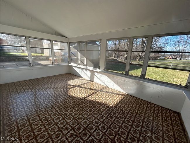 Unfurnished sunroom featuring a wealth of natural light and lofted ceiling | Image 27