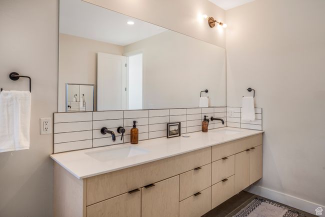 Bathroom featuring tasteful backsplash, double vanity, baseboards, and a sink | Image 27