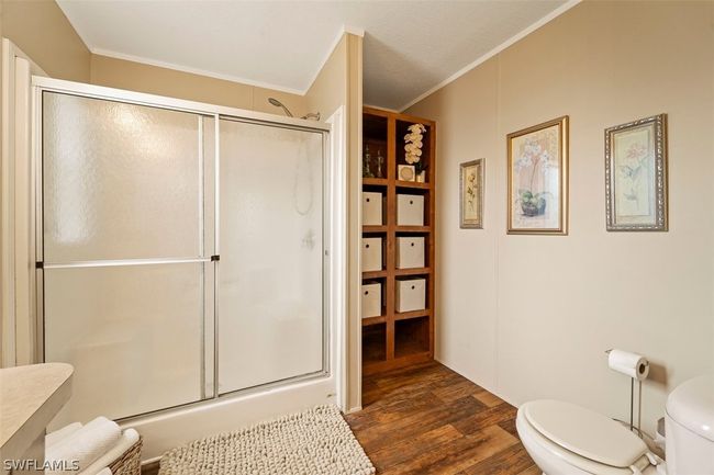 Bathroom with walk in shower, ornamental molding, toilet, and wood-type flooring | Image 16