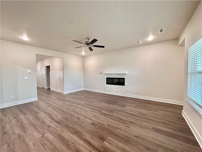 Unwind and embrace the warmth of the gas fireplace, creating a cozy ambiance on chilly evenings, while your feet revel in the luxury vinyl plank flooring, adding a touch of elegance to every step. | Image 5